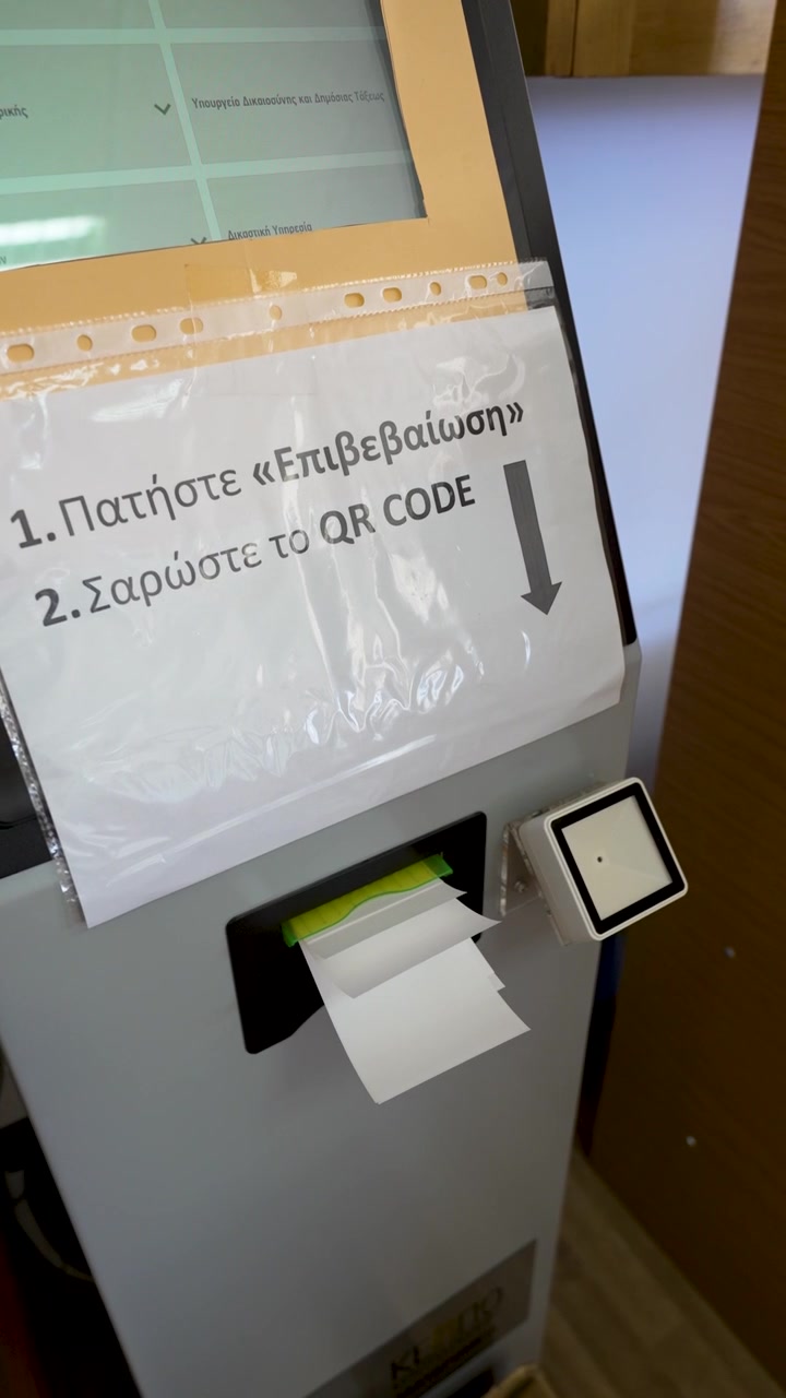 Un utente si avvicina al chiosco, legge i passaggi sul cartello e si prepara a scansionare un codice QR. La macchina fornisce istruzioni stampate sul suo utilizzo.