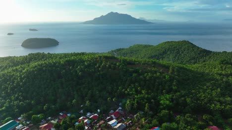 Small-asian-neighborhood-behind-green-covered-mountains-and-sea-during-sunrise