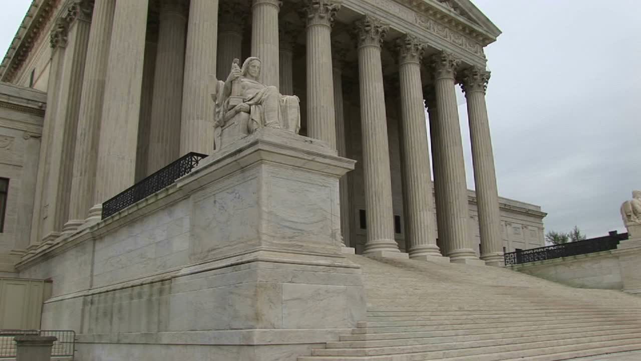 una vista de gusano de las escaleras y la entrada con columnas a la corte suprema