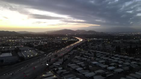 Disparo-De-Dron-Descendente-De-La-Autopista-En-Hora-Punta-Después-De-La-Puesta-Del-Sol