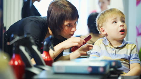 little child getting his hair cut at the hairdressing saloon