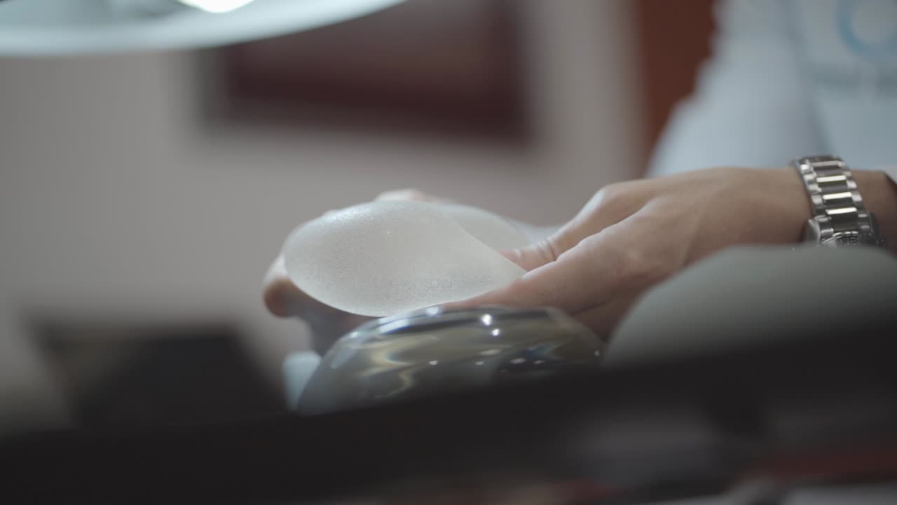 의사가 환자의 실리콘 유방 의식을 조작하고 있습니다.