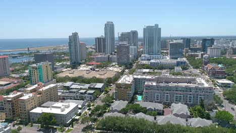 aerial drone flight across downtown st petersburg skyline with pier and gulf of mexico in the distance