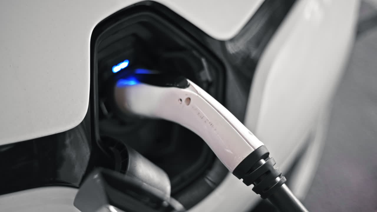 Plugged charger into an electric car, blue flickering light in the socket