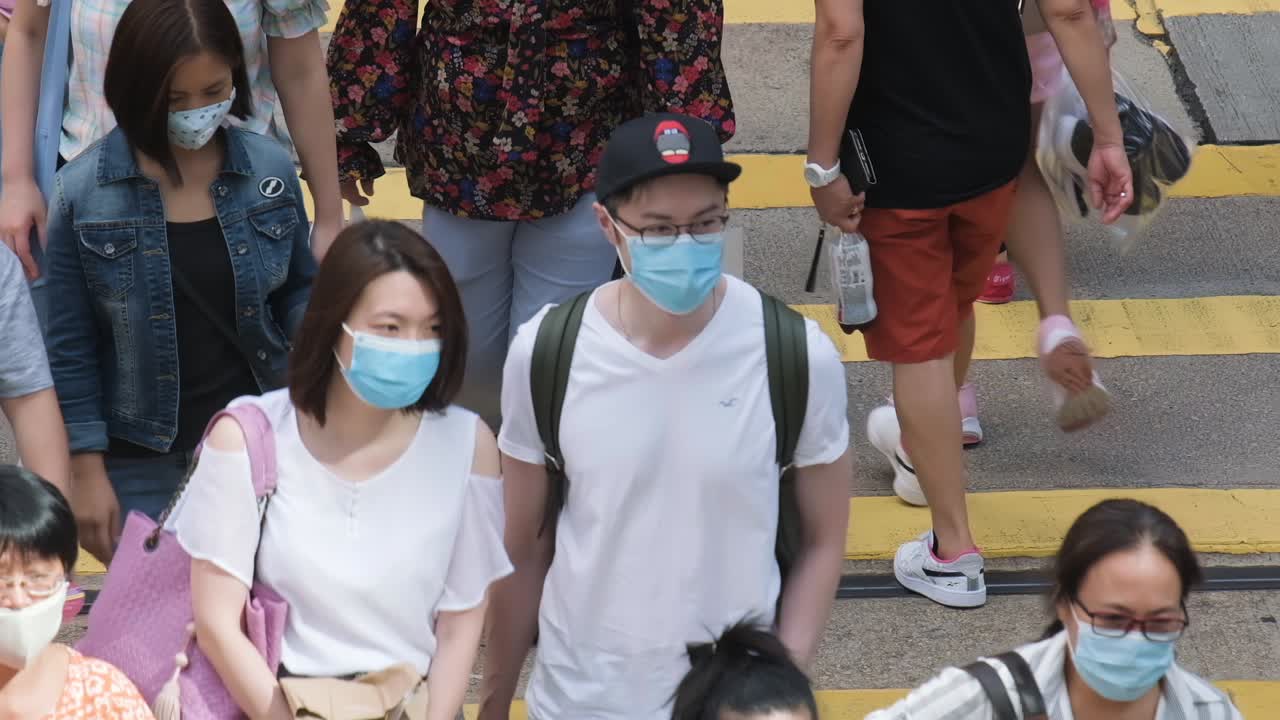 Hong Kong - July 5, 2020: Slow motion of crowd people wearing medical face masks in Hong Kong. Covid-19 concept.