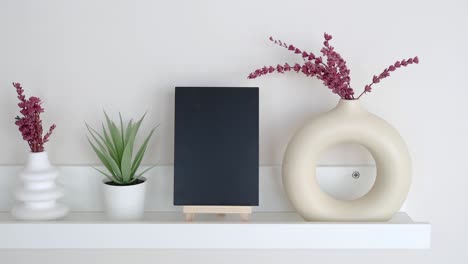 modern shelf decor with vases, plant, and chalkboard