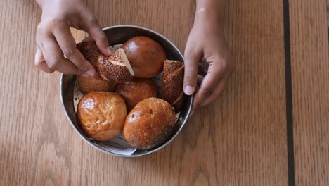 close up of hands holding a basket of fresh rolls