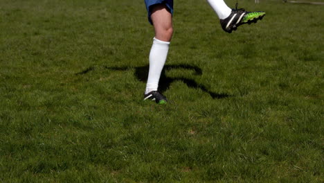 football player kicking the ball on grass