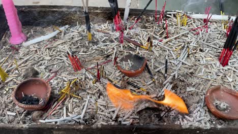 Shot-of-the-fire-lightened-in-the-temple-with-dhoop-sticks-and-lamps-on-the-mud-place-for-lightening-the-lamps-for-god