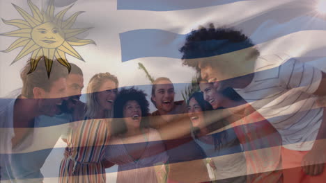animation of uruguay flag waving over diverse friends forming human chain at beach