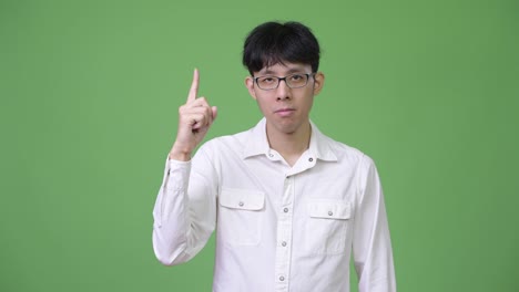 young asian businessman pointing up