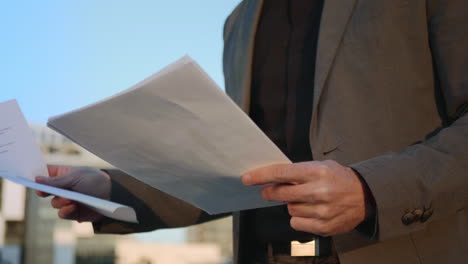 businessman hands reading documents on street. male manager keeping papers