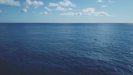 Mar-En-Día-Soleado-Vista-Aérea-Sobre-Olas-Y-Horizonte-Con-Cielo-Azul