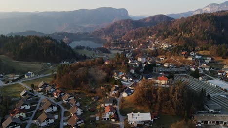 springtime slovenia, bled lake shimmers beyond hills, rooftops, peaceful sunrise