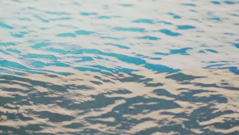 Slow-motion-shot-of-blue-water-rippling-on-the-surface-of-a-swimming-pool