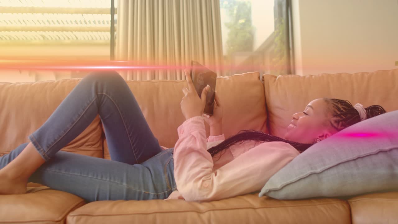 Woman lying on sofa in technology-themed living room tapping phone, flare appearing, answering call