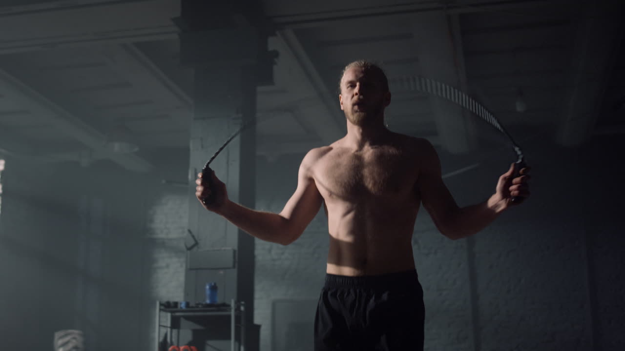 Uomo che fa allenamento cardio con la corda per saltare. Sportivo che salta la corda.