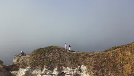 couple walking along cliffside