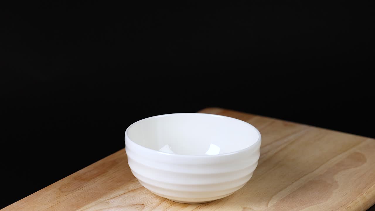 кусочки персика падают в белую миску