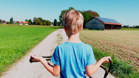 young boy walking in the countryside while holding a dog leash
