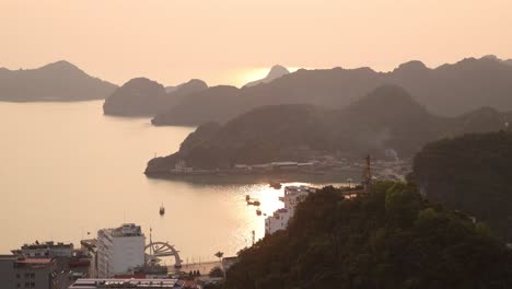 orange glow of sunset behind layers of mountains in cat ba and halong bay in northern vietnam