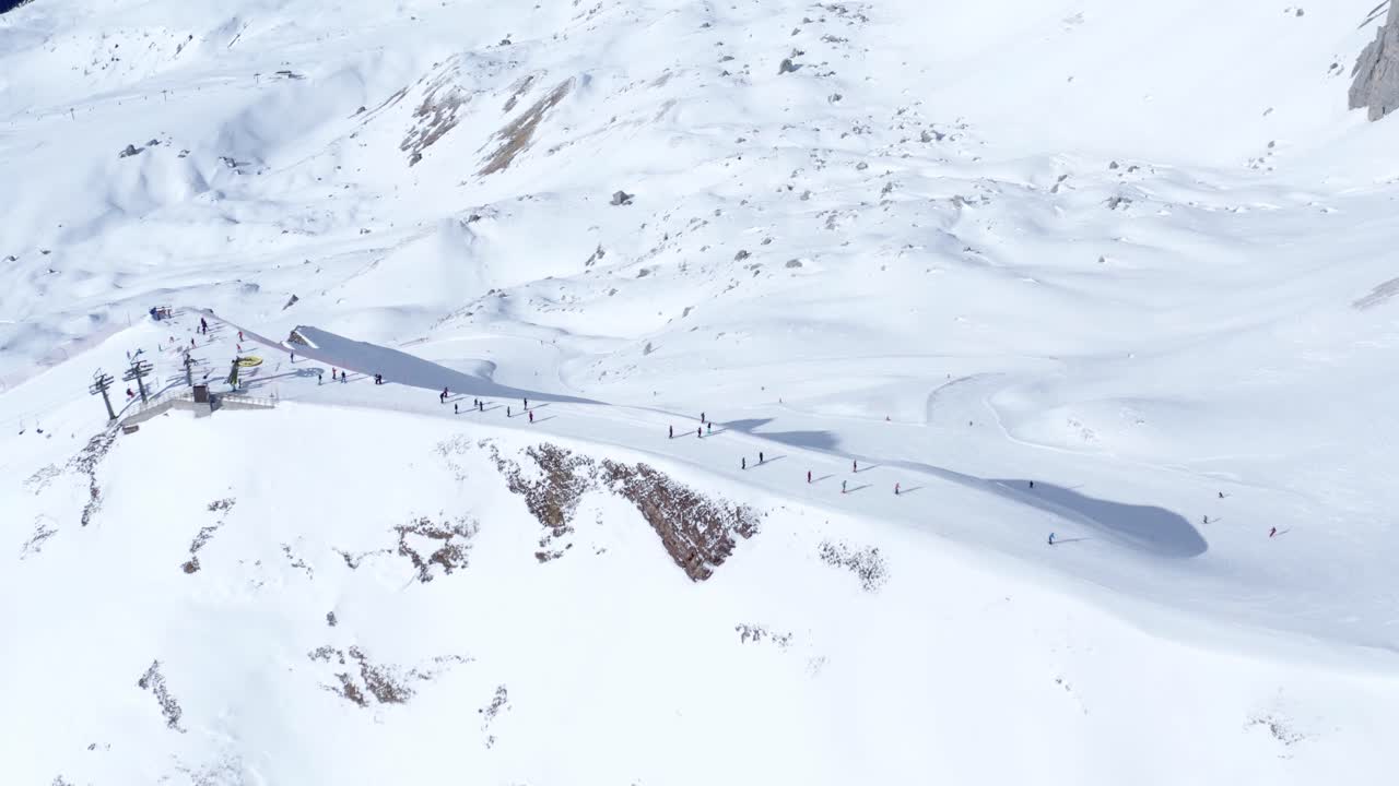 ⁇ 은 낮에 이탈리아 알프스 산에서 스키를 타고 내려오는 사람들의 드론 촬영