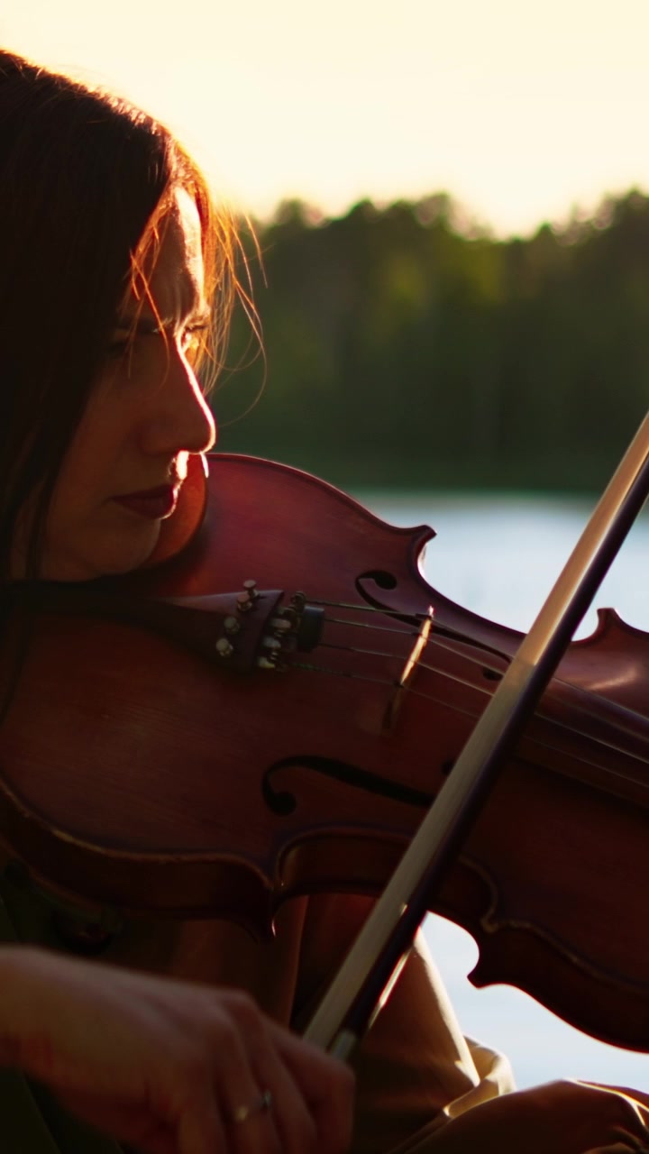 Woman Playing Violin Outdoors at Sunset