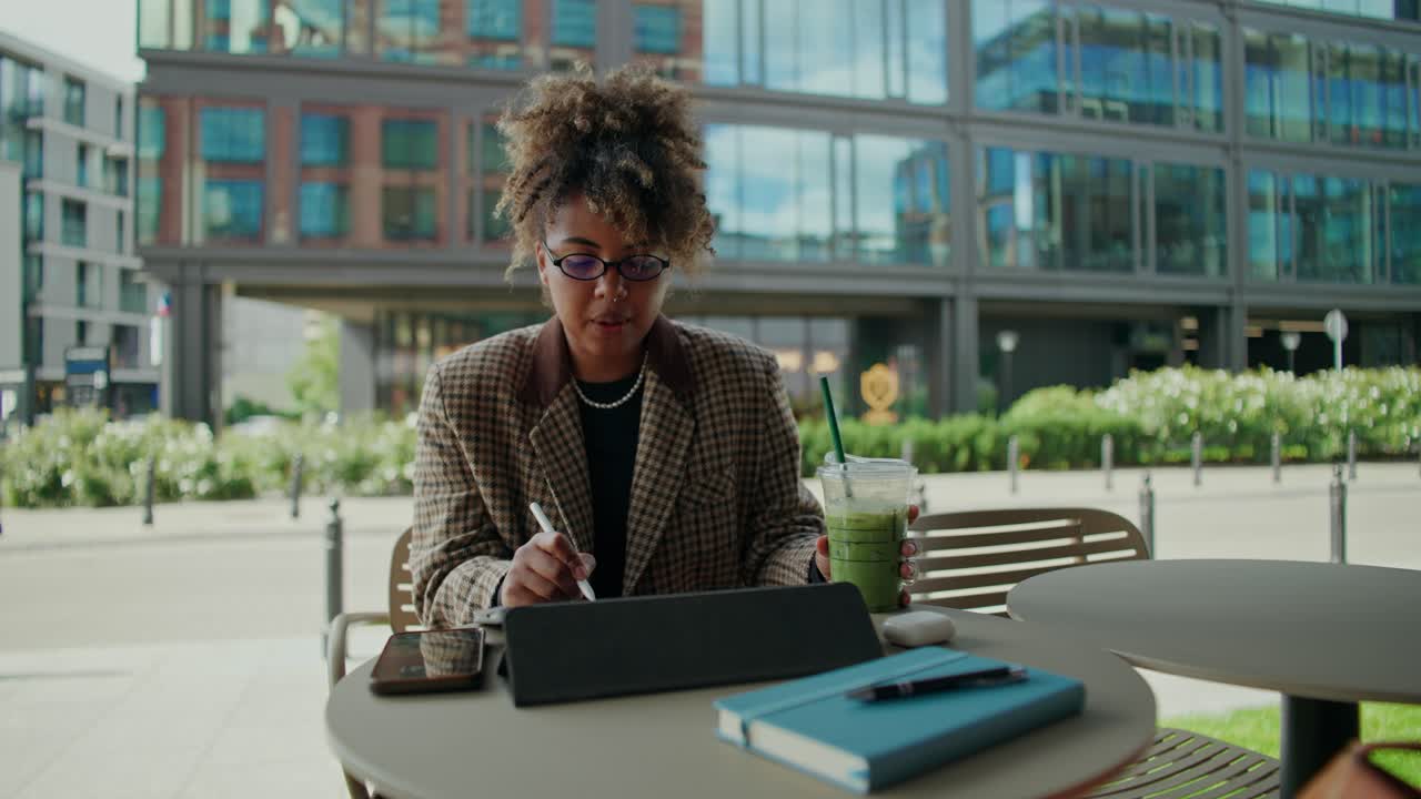 Woman working on digital tablet at outdoor cafe