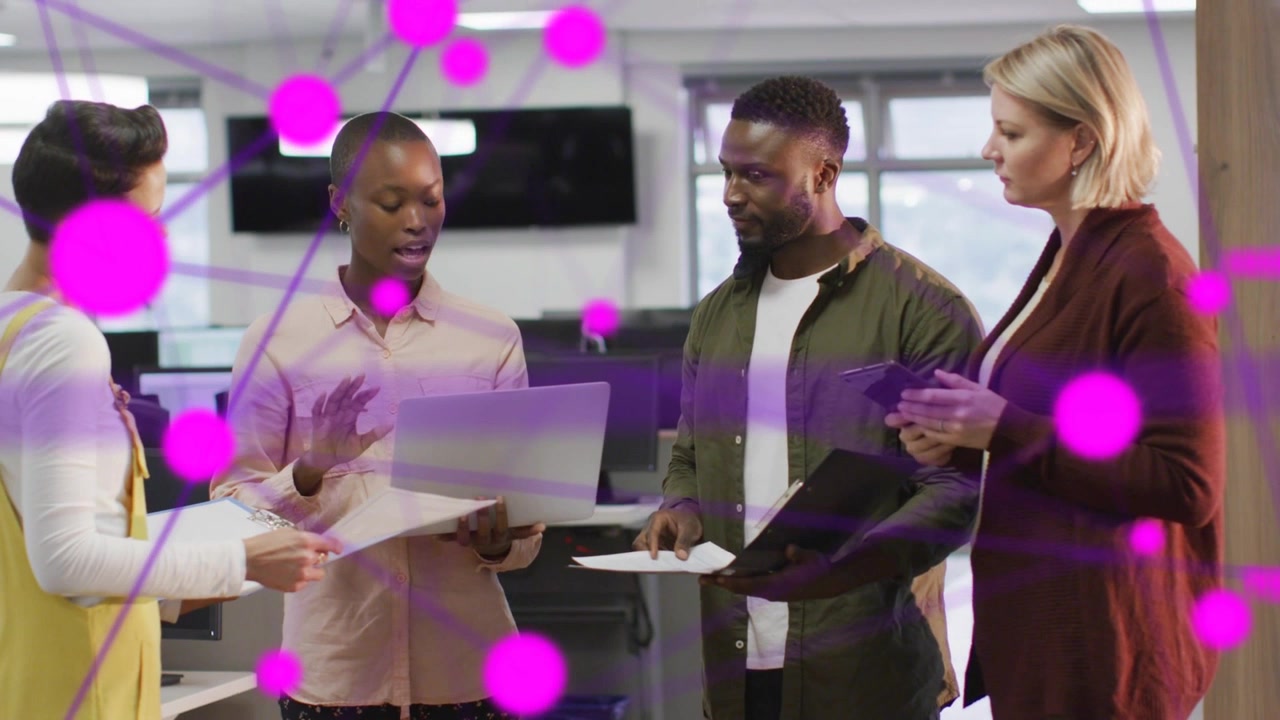 Lead handing file while tech team reviewing laptop and docs, magenta network appearing over group