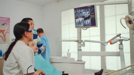 pediatric dentist showing on monitor teeth x-ray