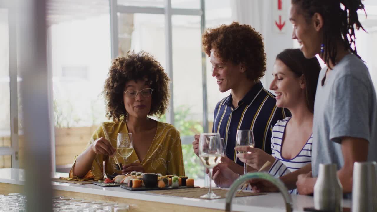 Four friends chatting at cafe bar, woman picking sushi as pals toasting, window overlays appearing