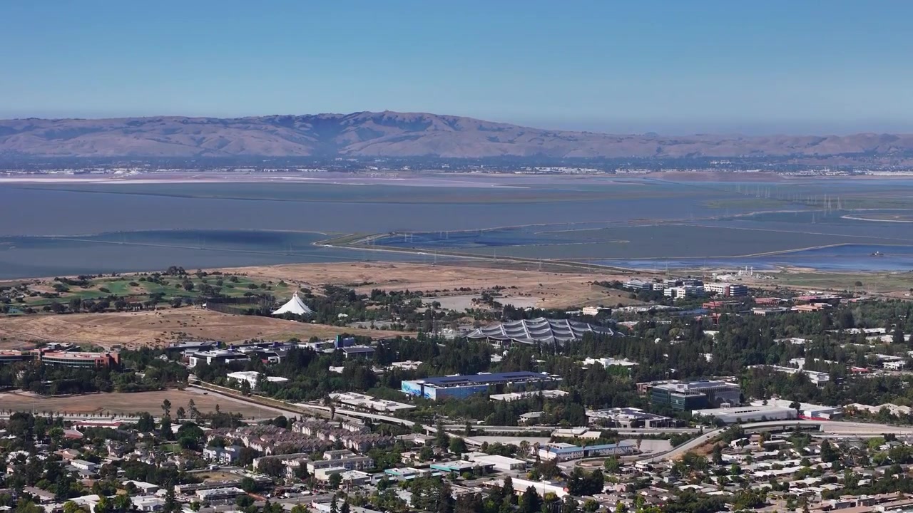 Vista panoramica aerea del campus del quartier generale di Google a Mountain View, California, con le saline, le paludi della Baia di San Francisco e le colline dell'East Bay sullo sfondo in una giornata limpida