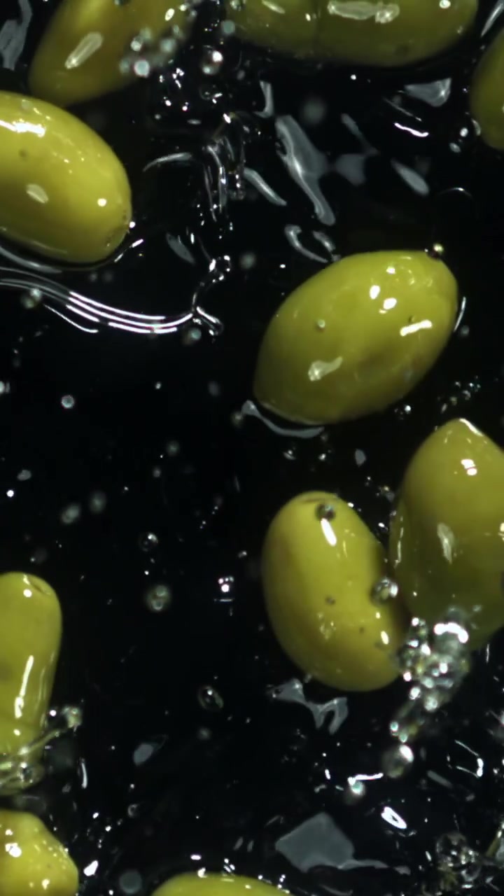 Schizzi d'acqua al rallentatore su olive verdi fresche