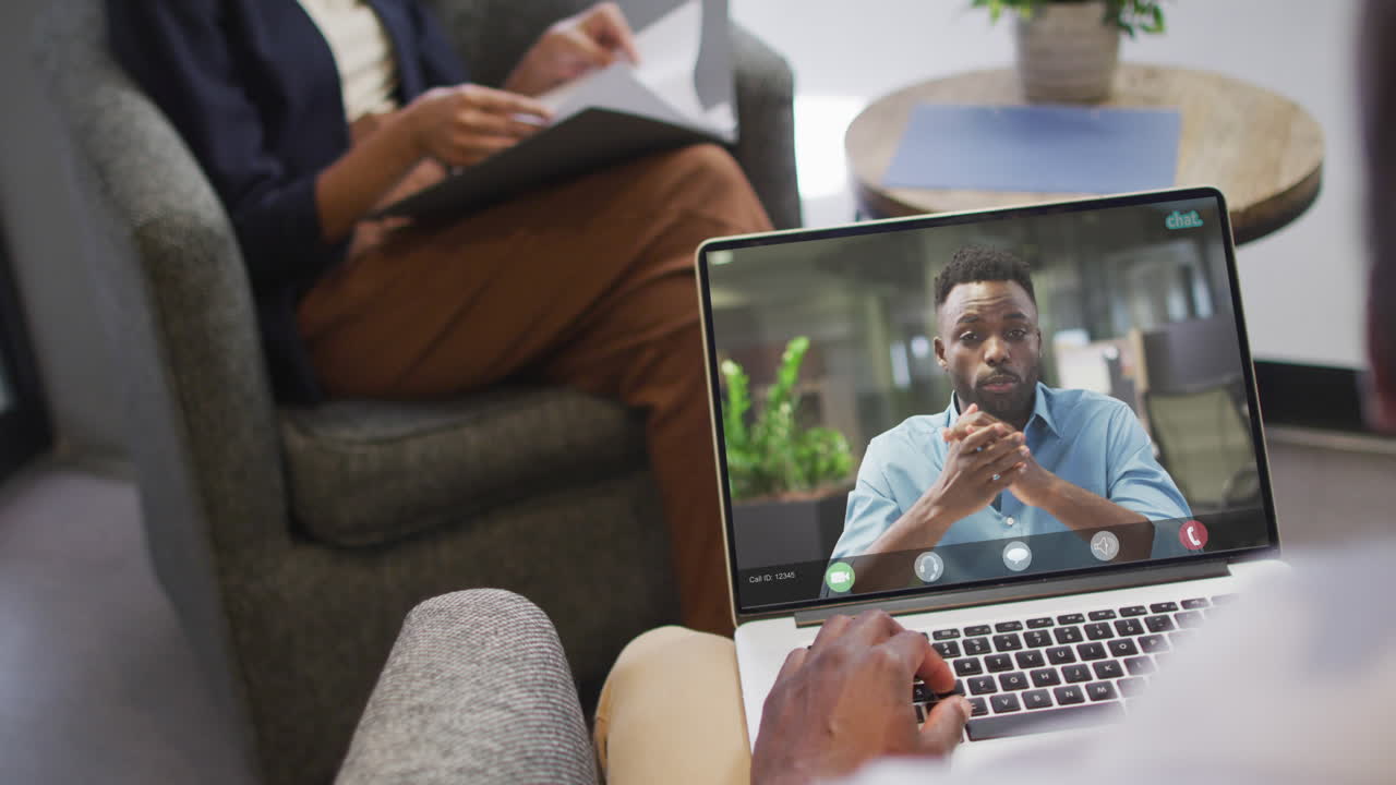 African american businessman using laptop for video call with african american business colleague