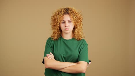 young woman with curly blonde hair and crossed arms