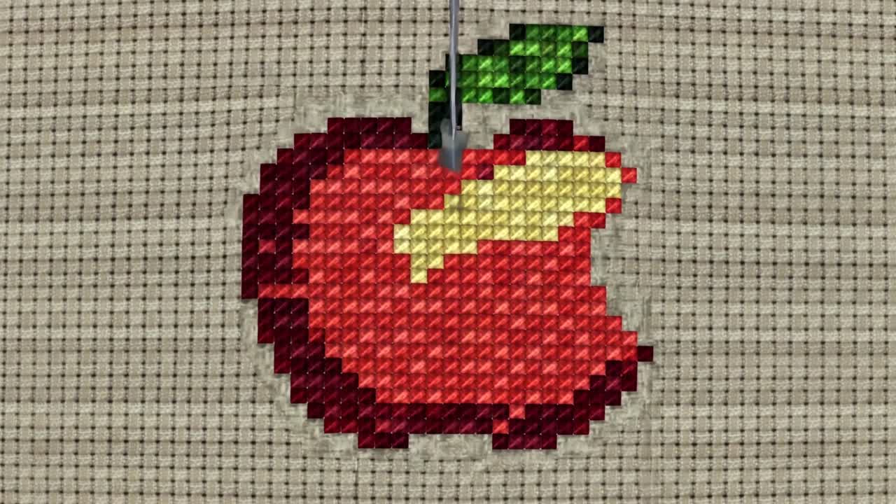 Aligning metallic needle moving into centered stitched bitten apple on beige Aida, showing threads