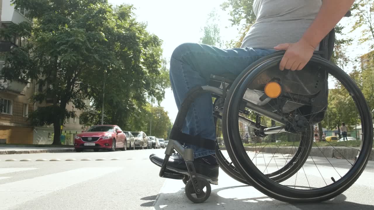 hombre con discapacidad en silla de ruedas cruzando la calle