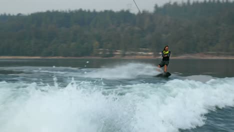 Front-view-of-caucasian-young-man-doing-tricks-on-wakeboard-in-the-city-river-4k