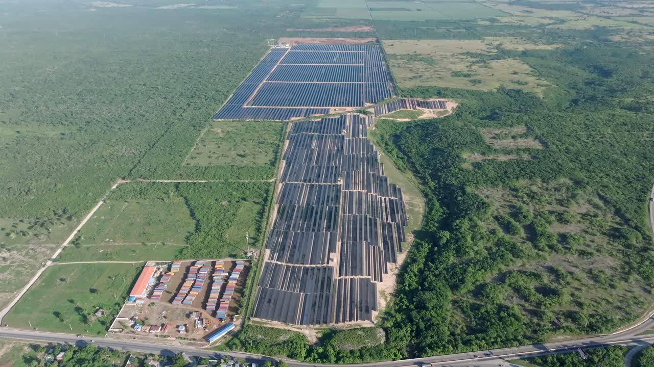 Aerial high angle view on solar panel park surrounded by forest landscape at sunny day