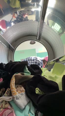 person loading clothes in a washing machine