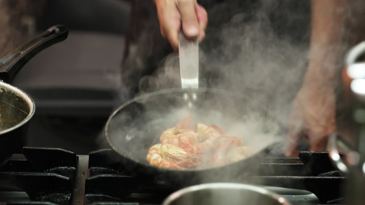 Chef Tossing Skillet Pan With Shrimps In The Kitchen Of A Restaurant. - medium shot