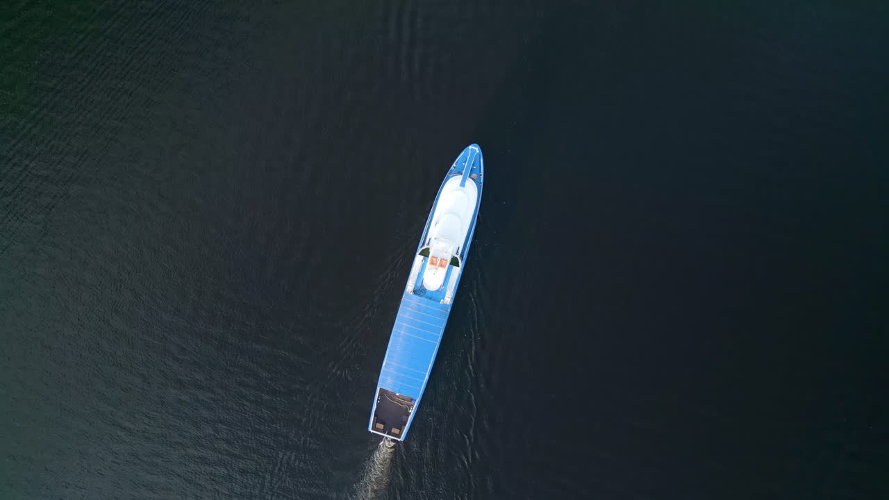 Aerial View of a Blue Boat on Dark Water