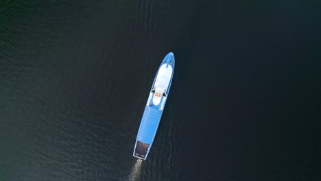 aerial view of a blue boat on dark water