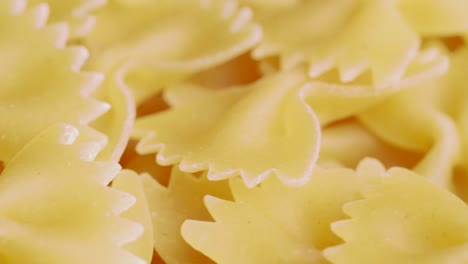 close up of raw italian farfalle pasta in motion
