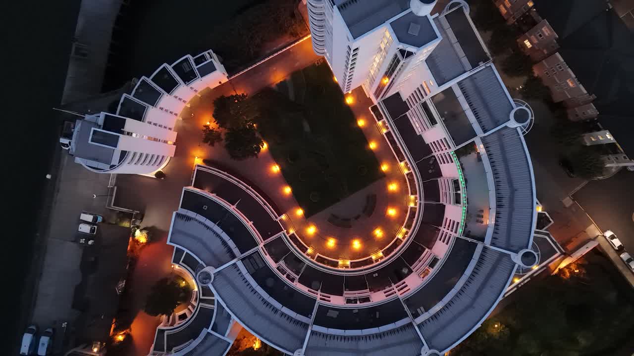 Bird’s-eye aerial view of the iconic Pierhead Lock building at Canary Wharf, London. Stunning architecture framed by waterways, modern skyline, and financial district atmosphere