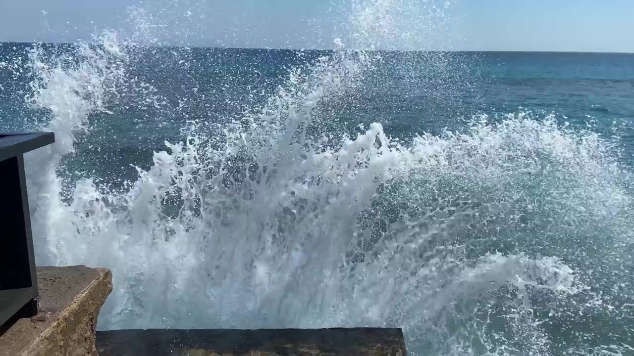 Olas del océano rompiendo contra un muelle de hormigón