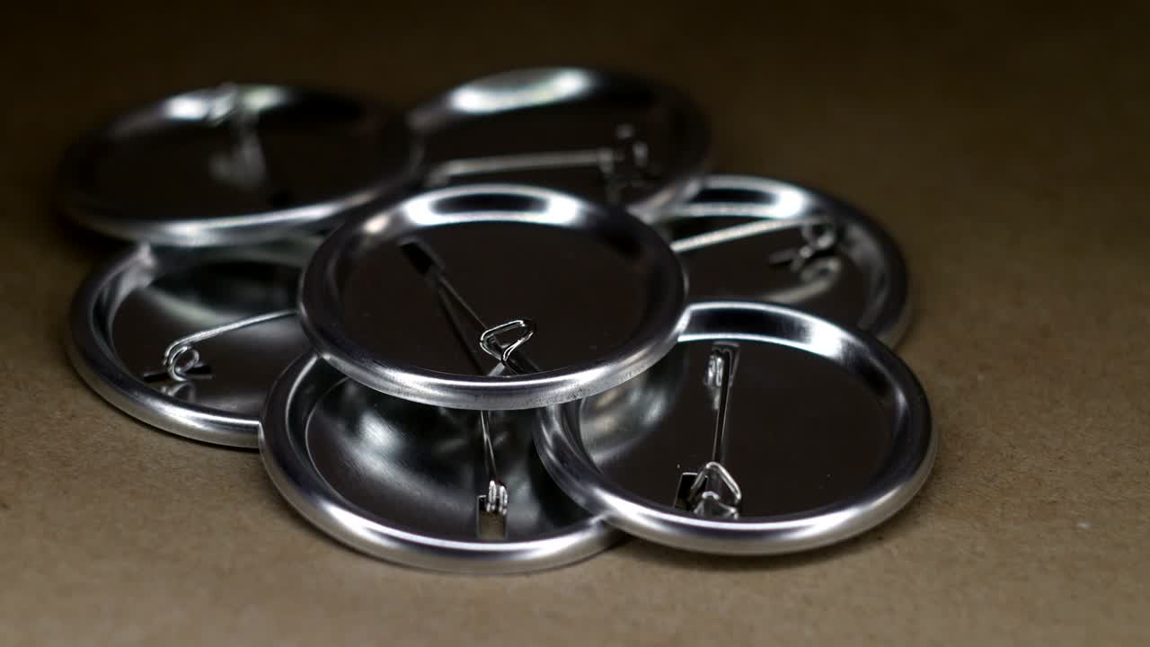 공예 종이 회전 테이블에 핀 배지 버튼 작업 조각의 더미