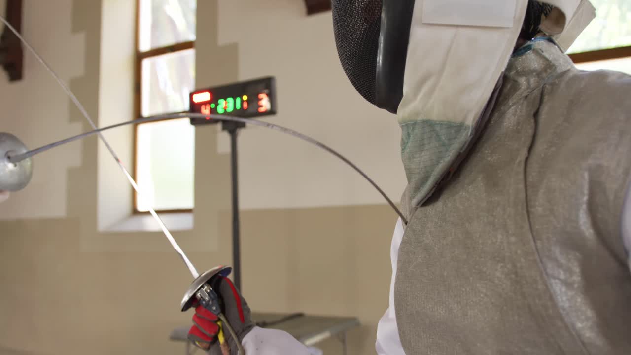 atletas de esgrima durante un entrenamiento de esgrima en un gimnasio