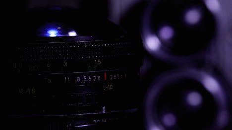 a vintage camera lens slowly rotates in a close up shot with dramatic contrast lighting