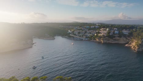 Aerial---Mediterranean-coastal-city-with-turquoise-water-bay,-Mallorca